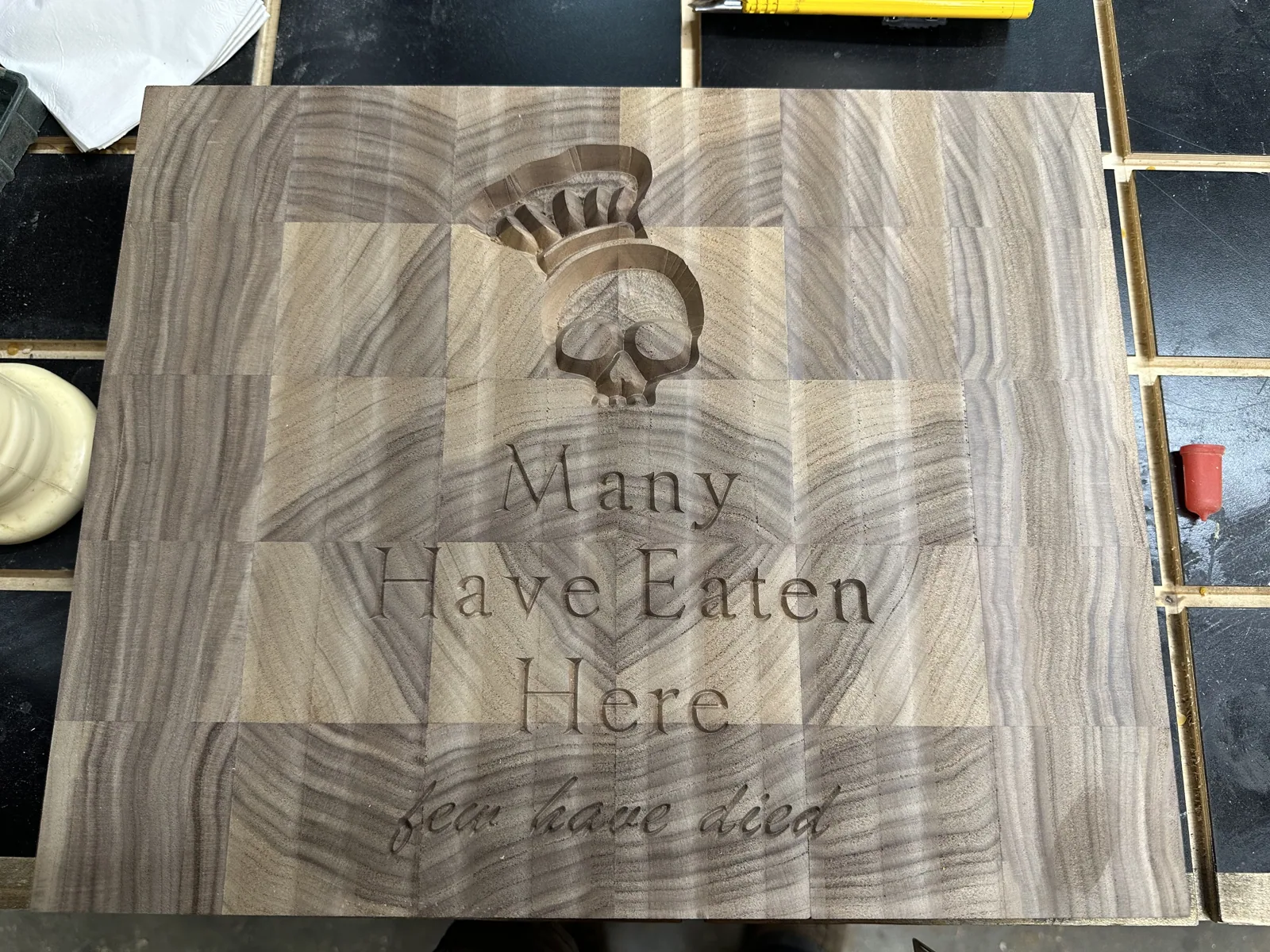 Maple inlay reading Many Have Eaten Here Few Have Died set into the walnut