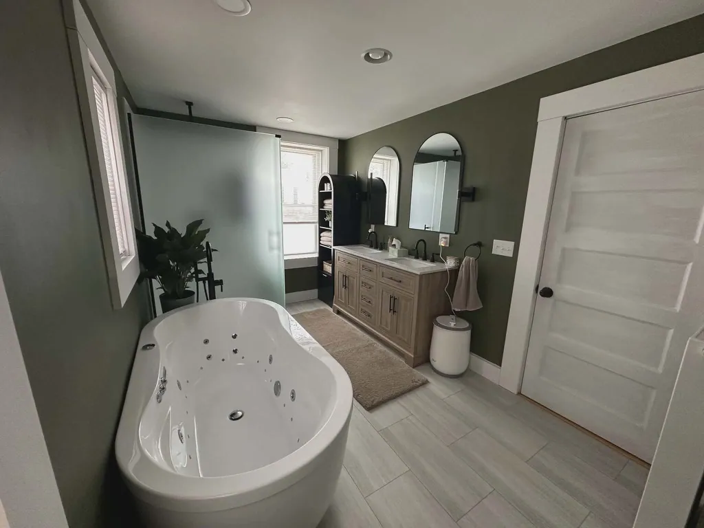 A full bathroom redesign with a freestanding soaking tub, double vanity, and tile floor.