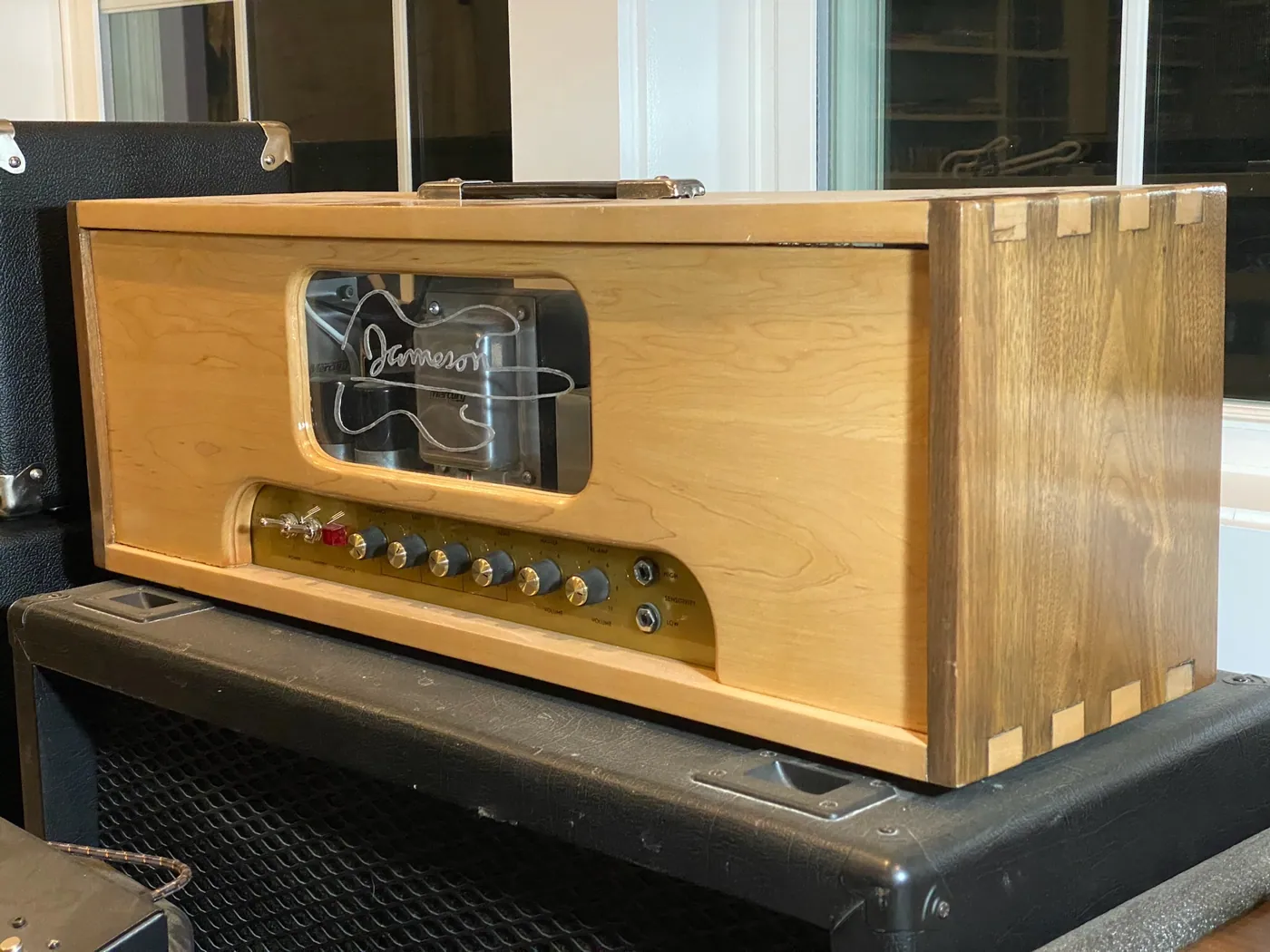 Custom guitar amplifier head in a dovetailed maple cabinet with an engraved window.