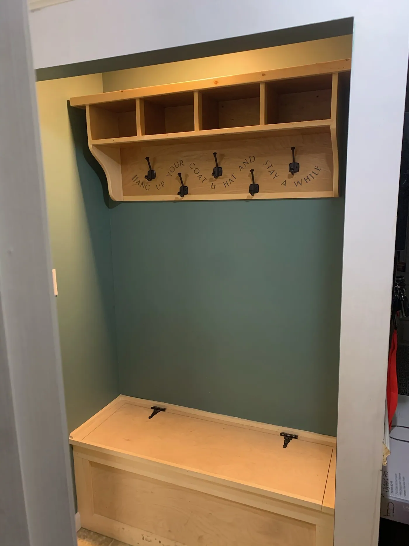 Built-in mudroom unit with cubbies, coat hooks, and a lift-top storage bench.