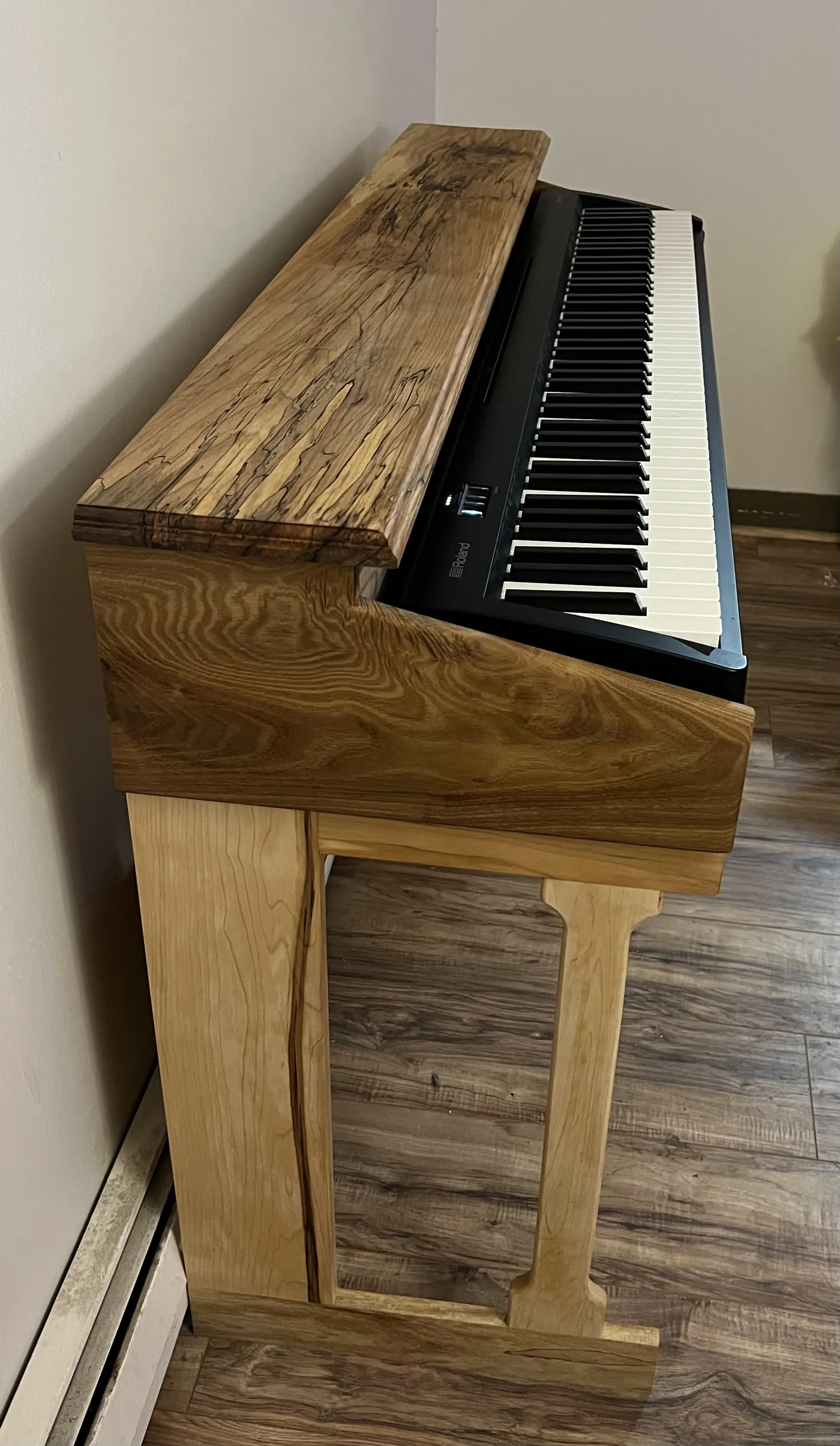 Console for a digital piano built around a single spalted maple top with live-edge character.
