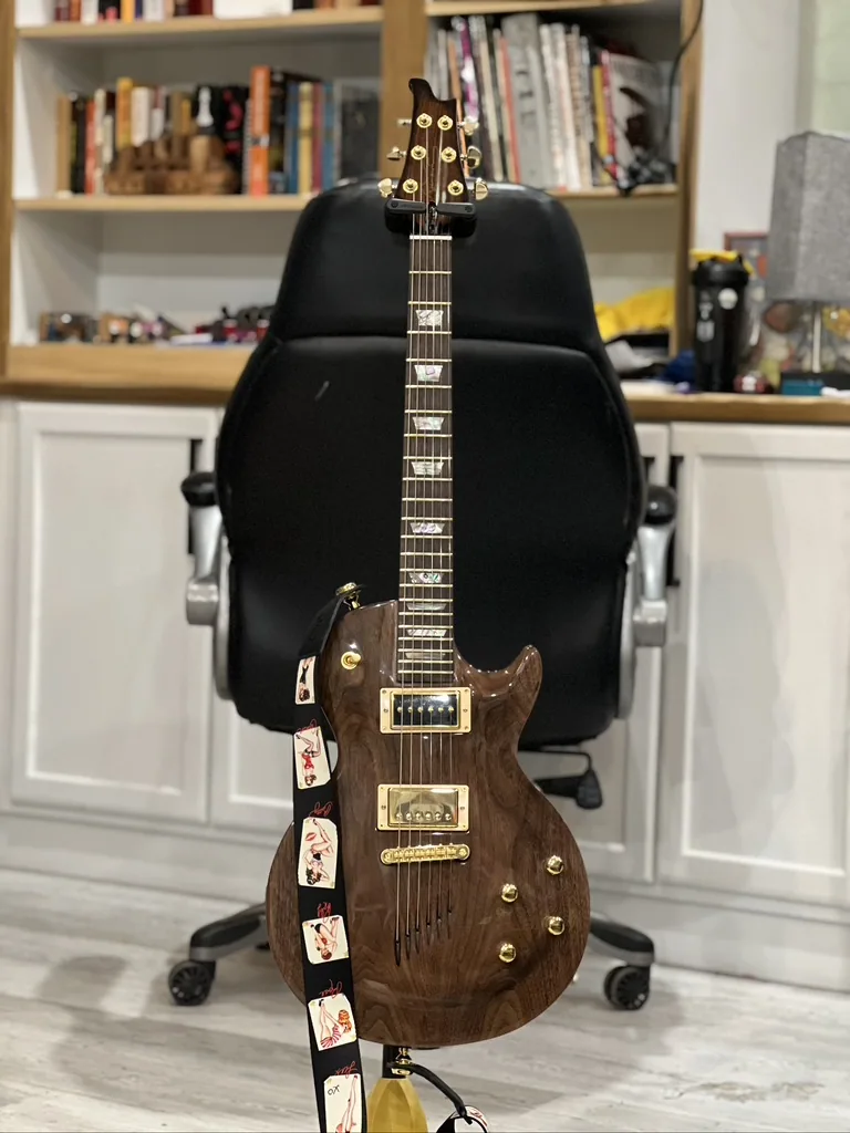 Finished custom Les Paul style guitar, front view, with a black walnut top and gold hardware