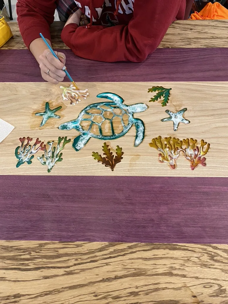 Colored epoxy filling the carved turtle and seaweed inlay