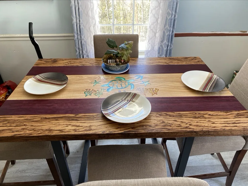 Purpleheart, ash, and zebrawood dining table with a hand-cut turtle inlay, set in a sunlit dining room